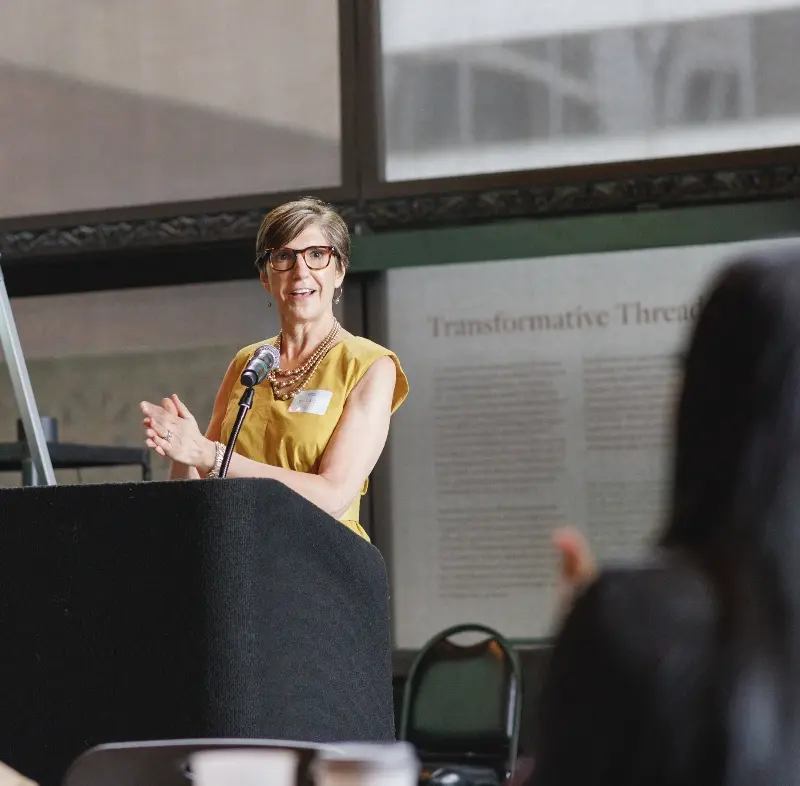 OneChiFam event, woman speaking at a lectern