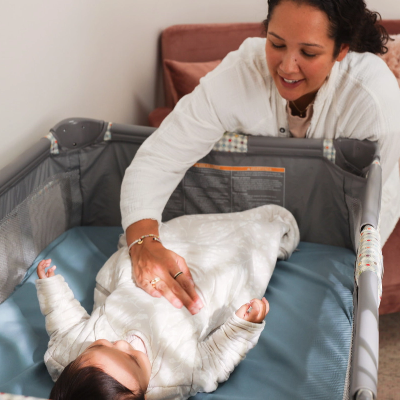 A mom checks on her baby in a crib